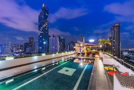 Outdoor pool, pool loungers. Furama Silom Bangkok Hotel