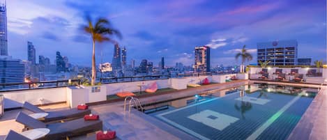 Una piscina al aire libre, sillones reclinables de piscina