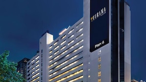 Un hôtel de grande hauteur, reconnaissable à son grand panneau « Furama », à ses nombreux étages et à son architecture moderne.