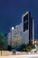 Un hotel de gran altura con un llamativo letrero 'Furama', varios pisos y un diseño arquitectónico moderno.