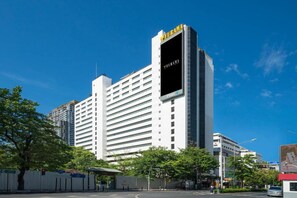 Ein großes, modernes Hotel mit einem gut sichtbaren 'Furama'-Schild, mehreren Etagen und einer glatten Fassade.