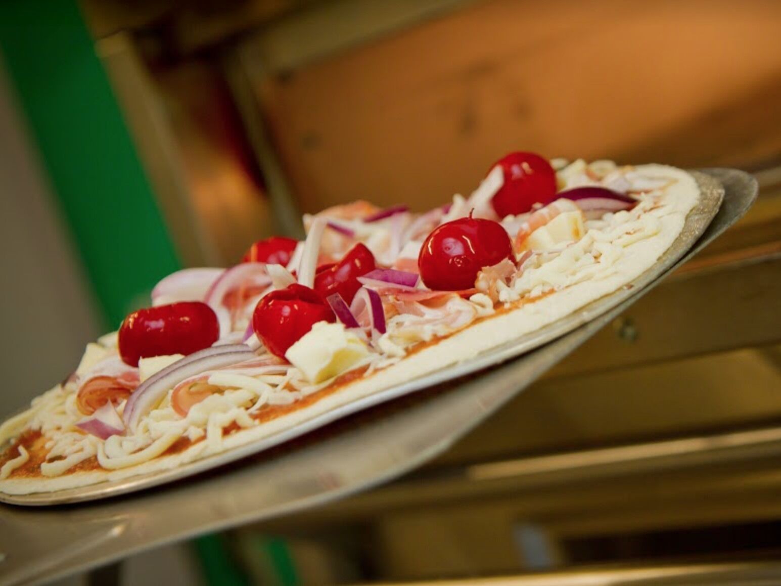 A pizza with toppings on a metal tray.