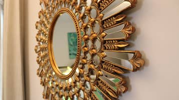 Un espejo montado en la pared con un marco ornamentado dorado.