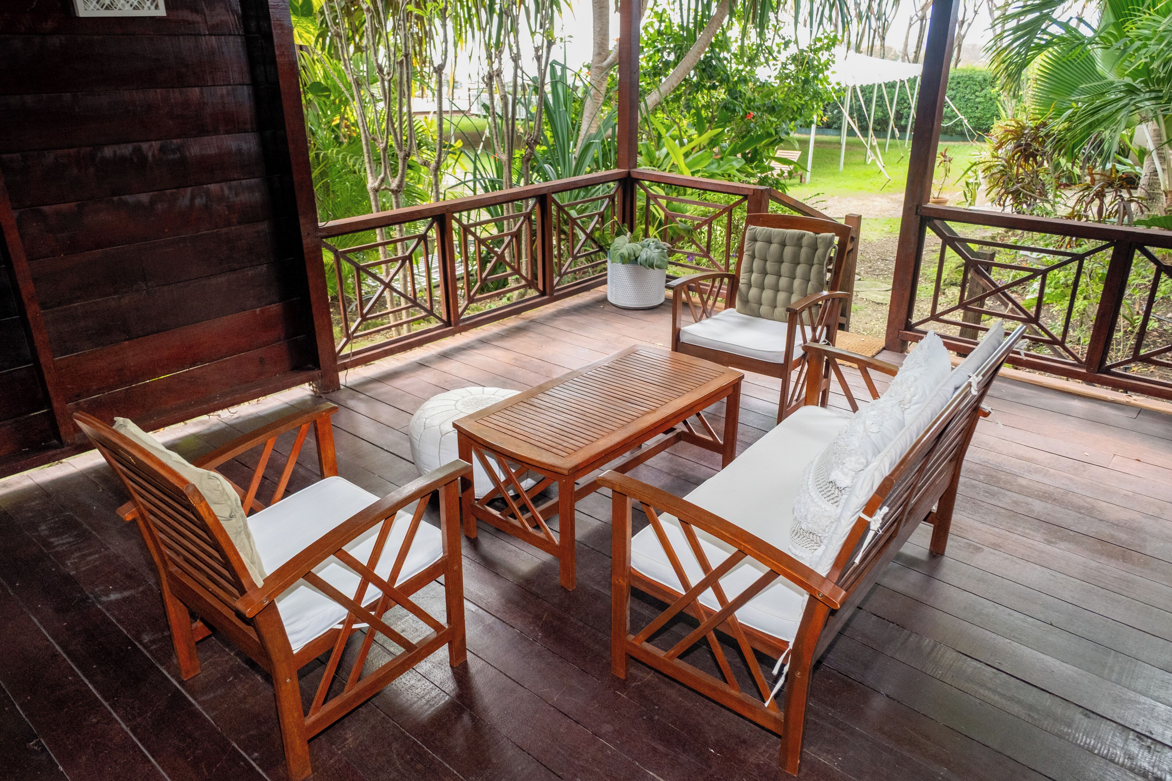 Una terraza de madera con un conjunto de sofá, una mesa y sillas.