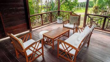 Una terraza de madera con un conjunto de sofá, una mesa y sillas.