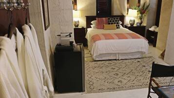 Une chambre d’hôtel avec un lit, une table de chevet, une lampe, un miroir et une chaise.