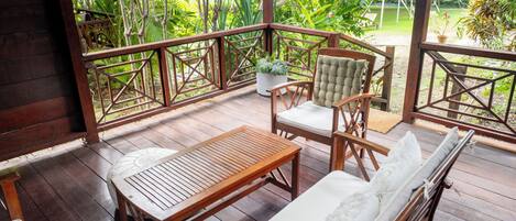 A wooden deck with a sofa, chairs, and a table.