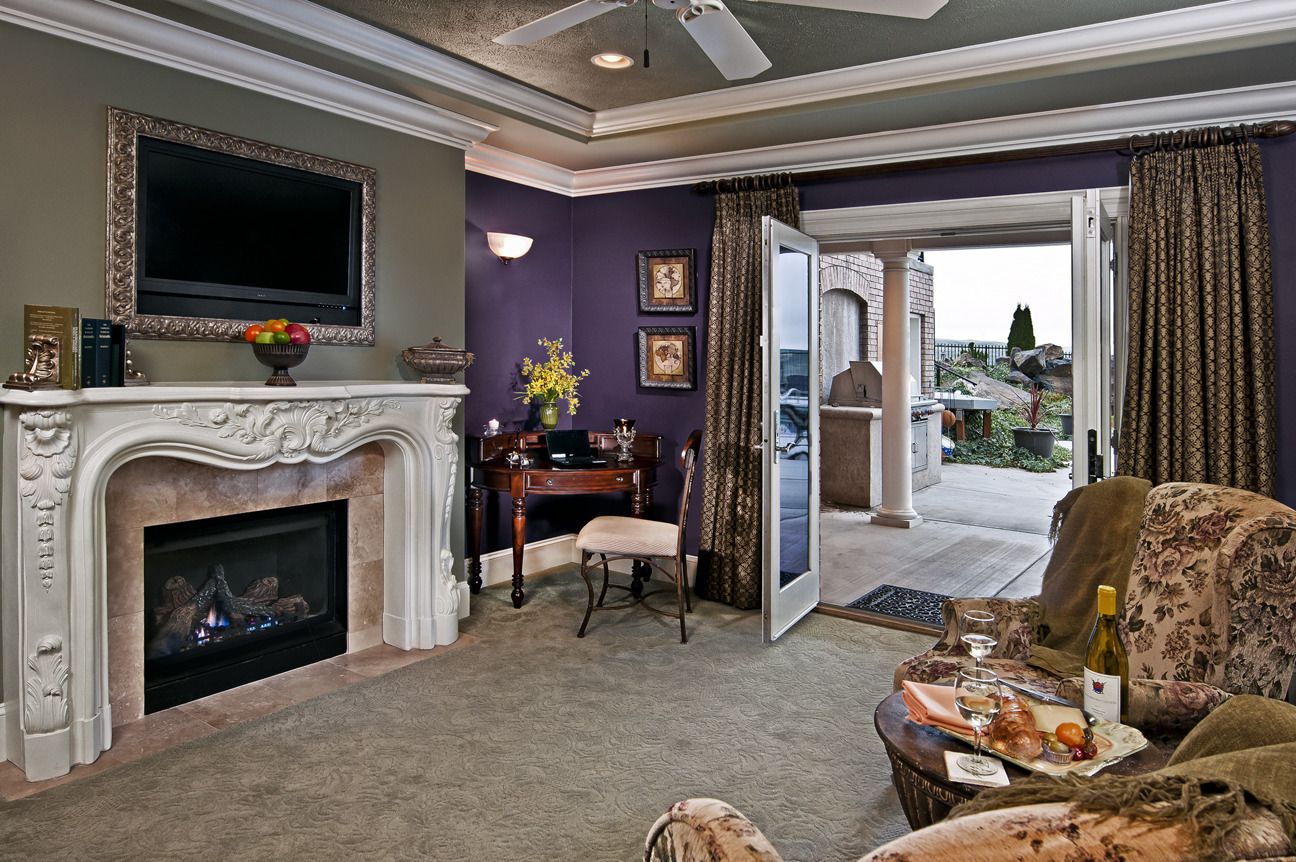 A living room with a fireplace, a television, and a dining area with a table set for two.