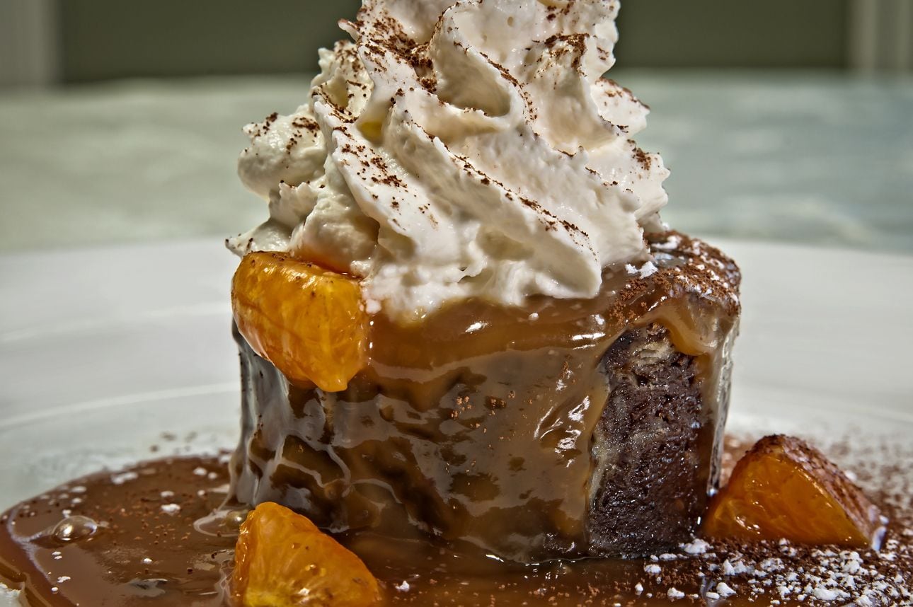 A dessert with whipped cream and caramel sauce.