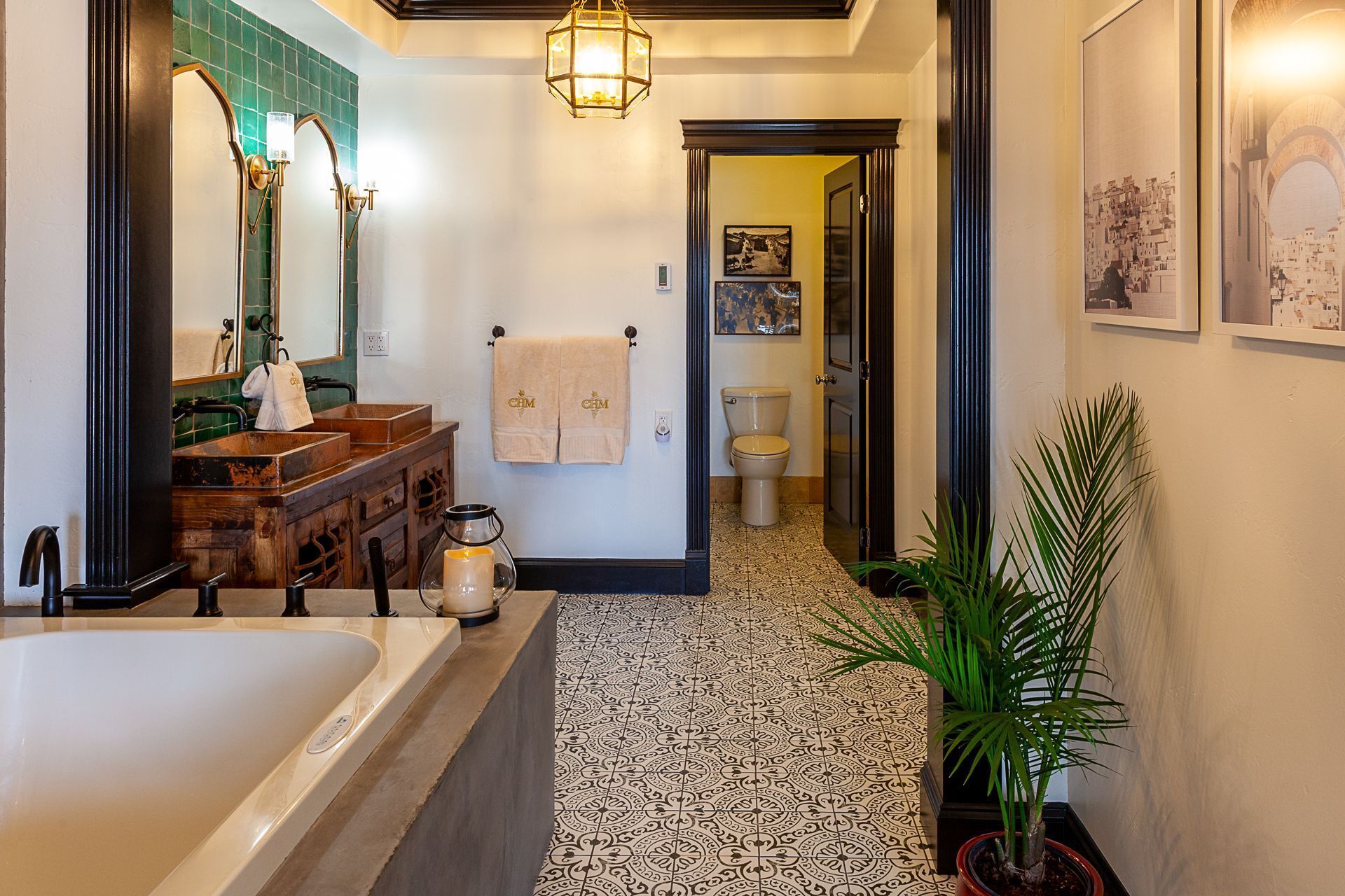 Un baño con una bañera, un tocador de madera, un lavamanos y un inodoro.