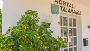 A building with a sign reading "HOSTAL TALAMANCA" and a number "15" on the door. - Hostal Talamanca (Santanyi)