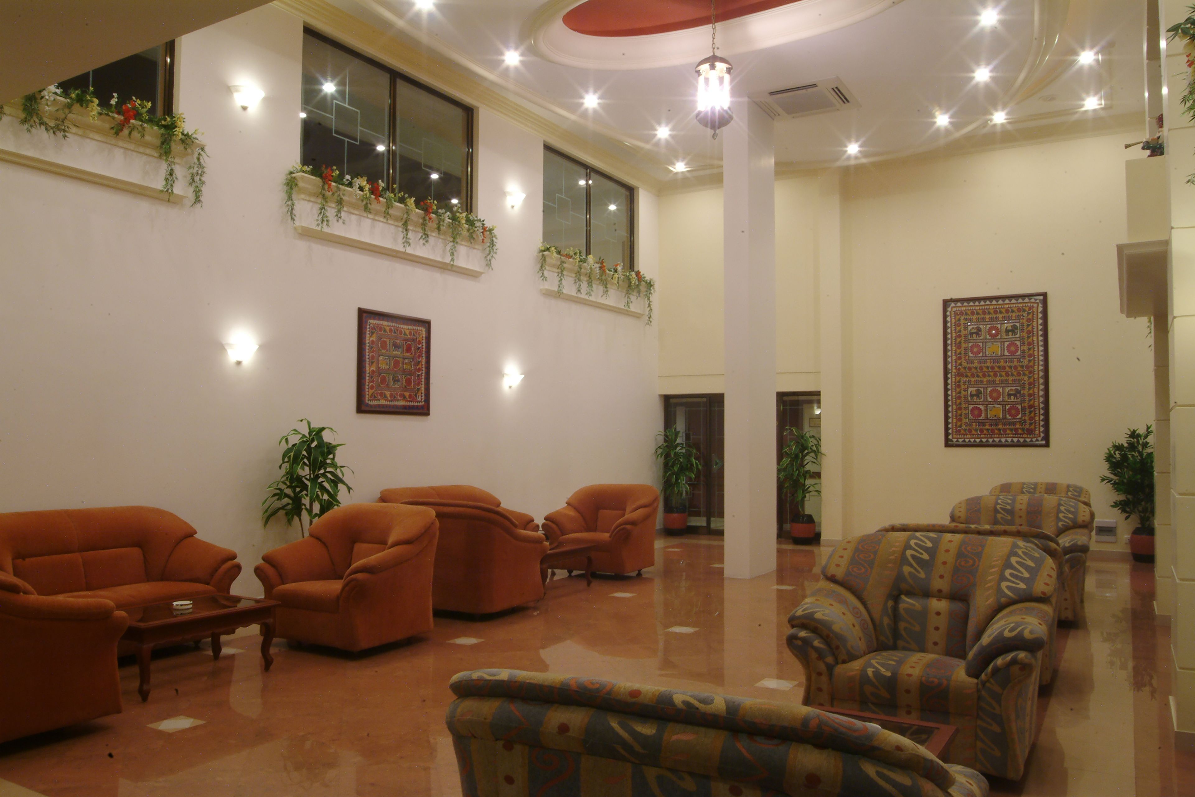 A spacious lobby with multiple seating areas, large windows with flower boxes, and decorative wall art.