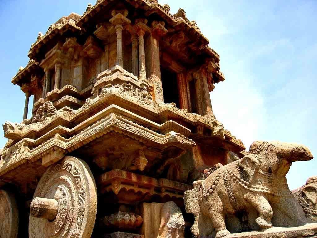 A stone structure with intricate carvings and a lion statue.