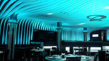 Un restaurante moderno con un diseño de techo curvo y mesas dispuestas para comer.