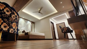 A modern bedroom with a bed, a chair, and a ceiling fan.
