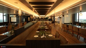 A long dining table with chairs, a bar area, and a view of the city.