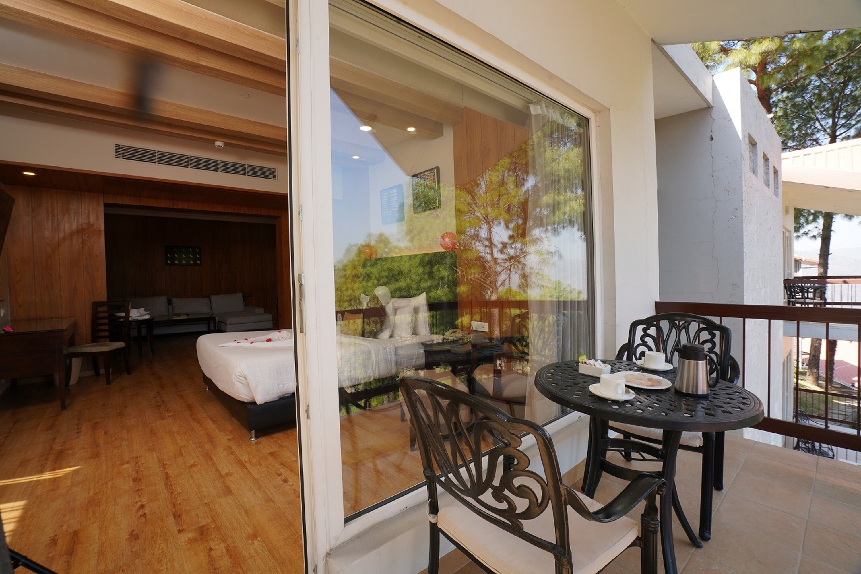A room with a bed, a desk, and a dining area with chairs and a table.