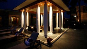 A covered outdoor seating area with lounge chairs and a pool. - Moksha Himalaya Spa Resort (Kasauli)