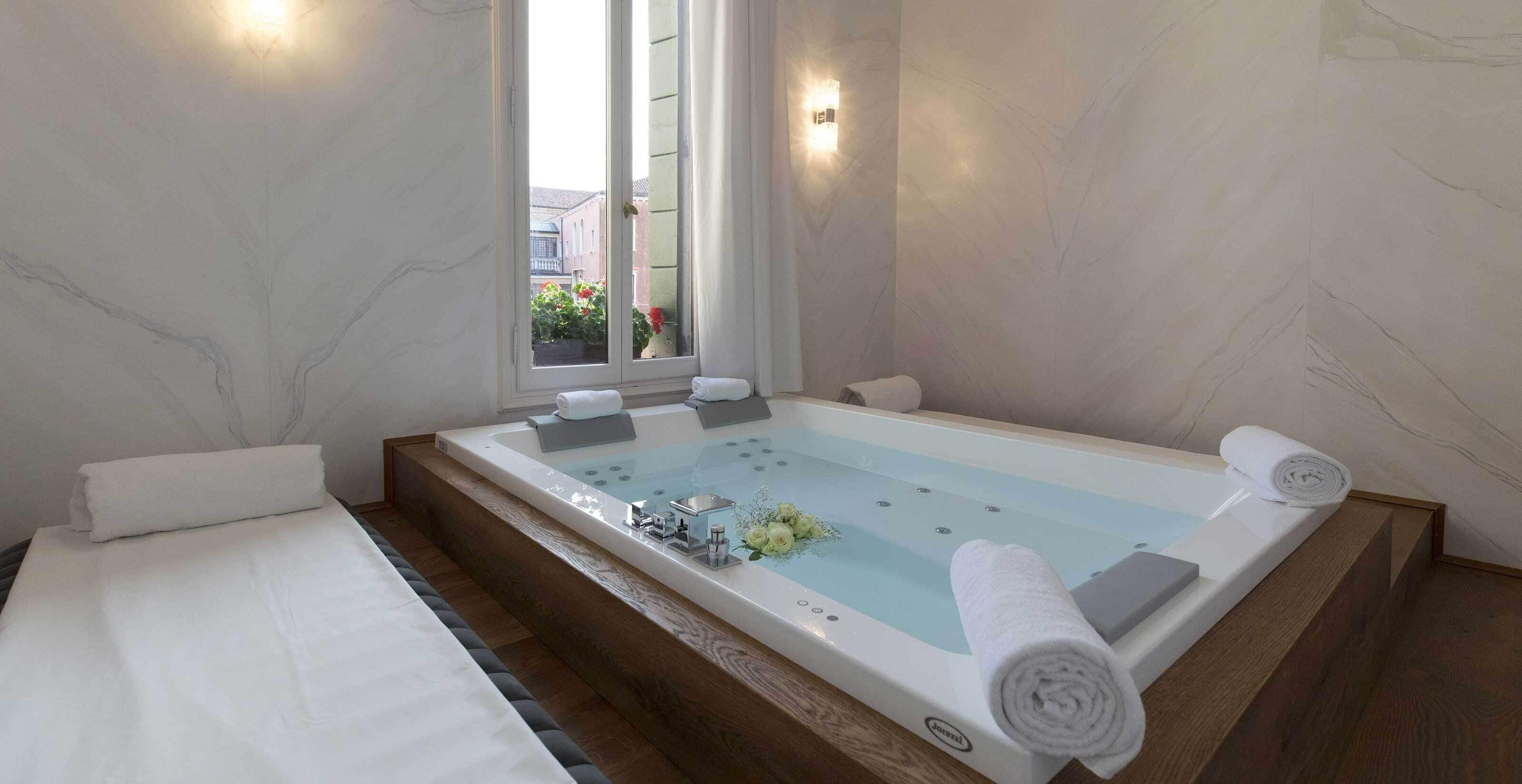 A modern bathroom with a bathtub, a window, and a view of the outside.