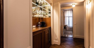 Ein Korridor mit Holzboden, einer Vitrine mit verschiedenen Gegenständen und einer Tür zu einem Badezimmer.