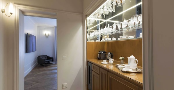 A hotel room with a wooden counter, a coffee maker, and a tray with teacups and a teapot. - Palazzo Paruta & Wellness Apartments (Venice)