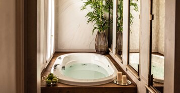 Un cuarto de spa con una bañera, una planta y velas.