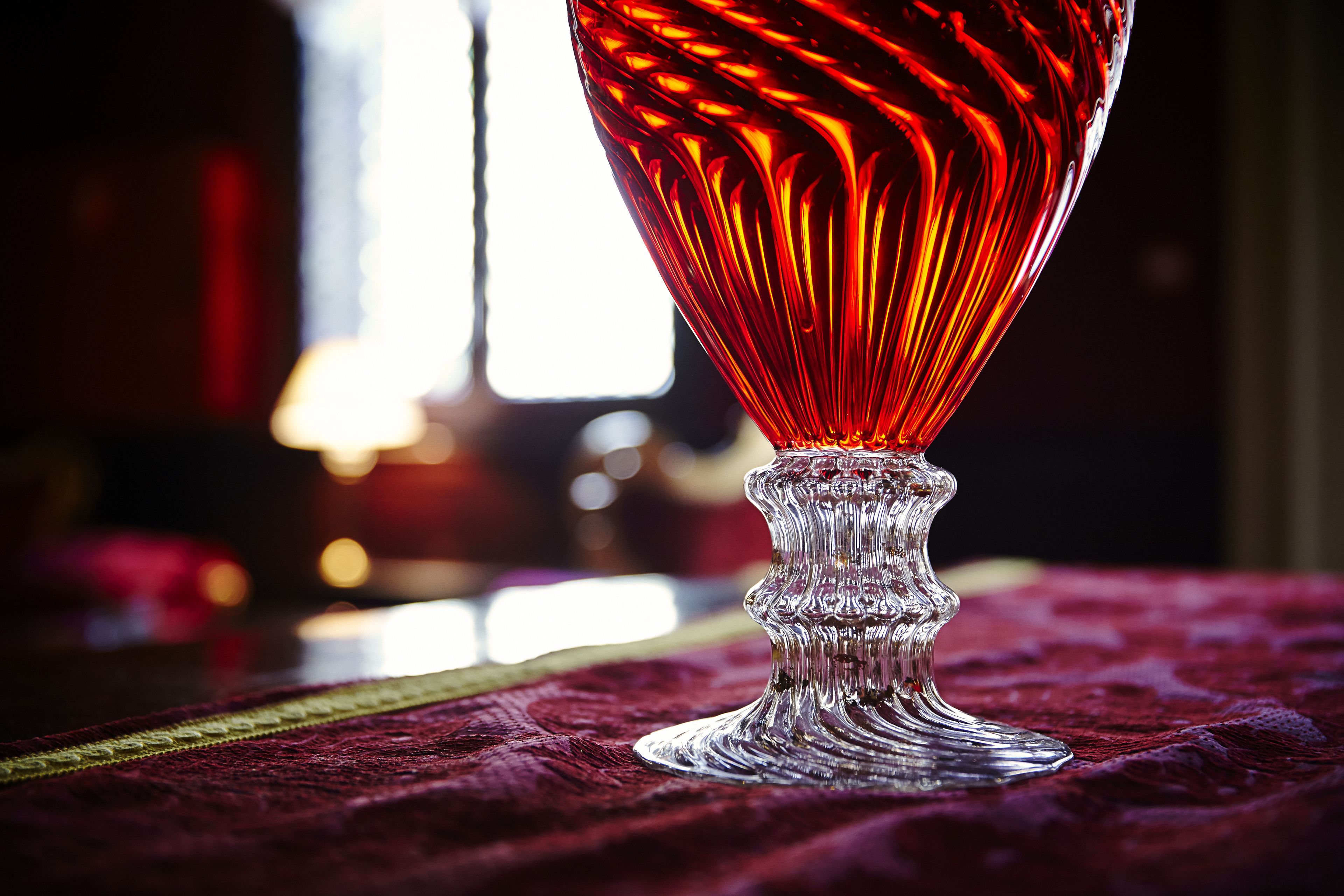 A clear glass object with a textured base, placed on a textured surface.