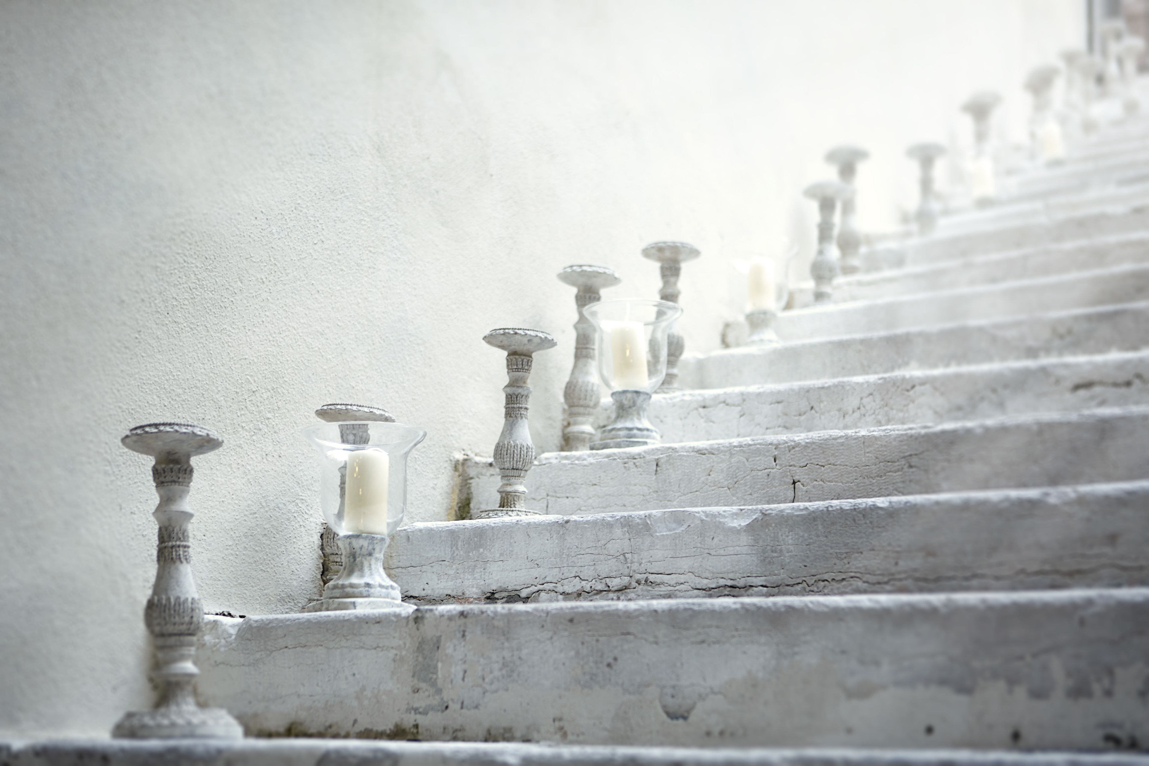Una escalera con barandales ornamentales y una pared blanca.