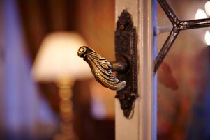 Un pomo con un diseño ornamental, un pestillo metálico y un marco de metal decorativo.