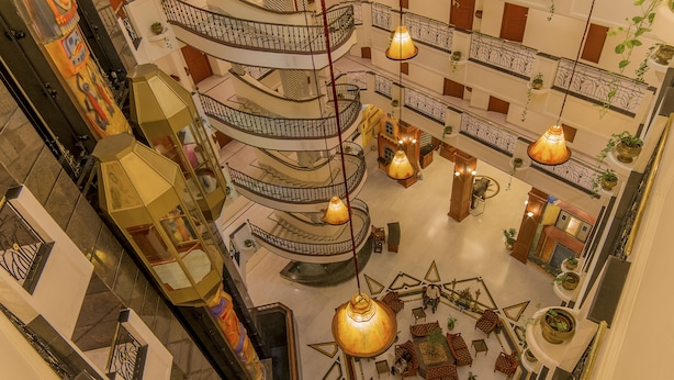 A multi-level atrium with a central open space, multiple balconies, and hanging lamps.