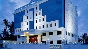 A modern hotel with a prominent entrance, large windows, and a well-lit facade.