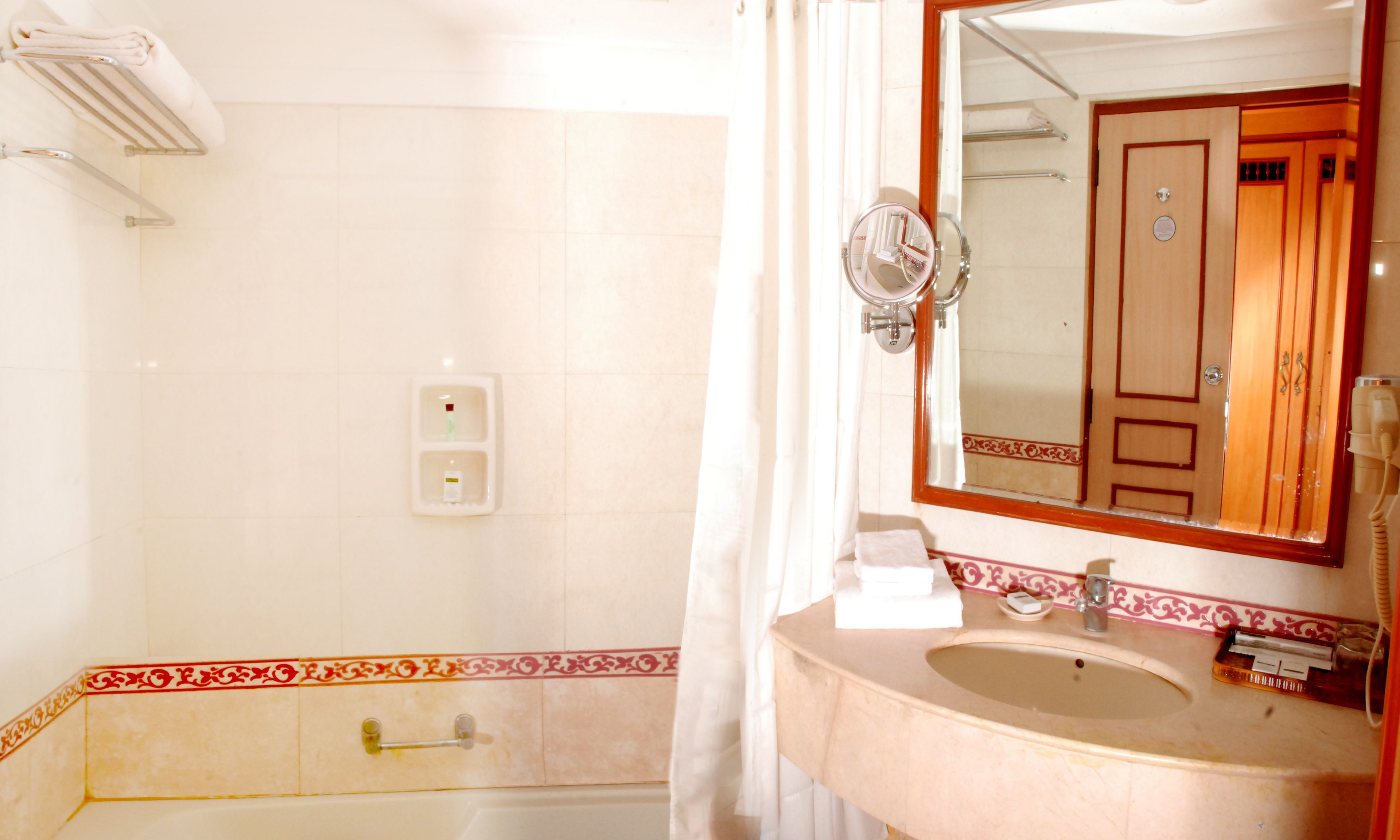 A bathroom with a sink, mirror, and shower.