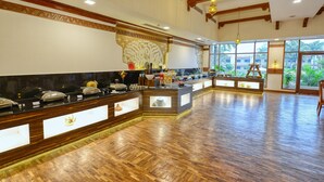 A spacious hotel lobby with a long reception desk, wooden flooring, and large windows offering a view of the outdoors. - Clarks Khajuraho (Rajnagar)