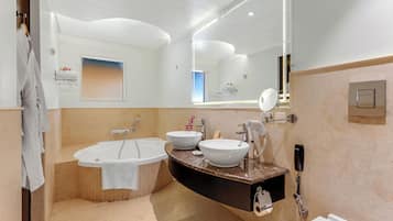 Une salle de bain moderne avec une baignoire sur pieds, deux vasques, un meuble-lavabo avec un miroir et un porte-serviettes.