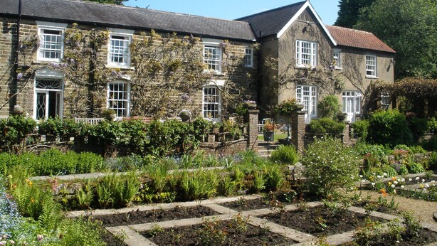 A stone building with multiple windows and a garden in front. - Lastingham Grange (York)