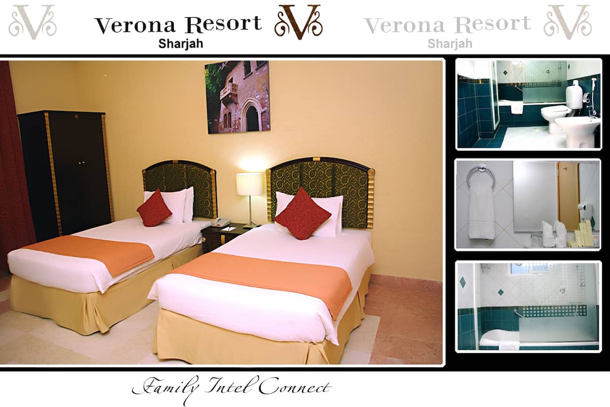 Habitación de hotel con dos camas, un armario, baño con ducha y vistas al exterior.