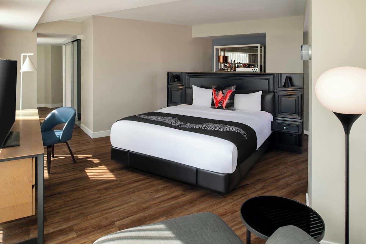 Een moderne hotelkamer met een groot bed, een bureau, een stoel en een televisie.