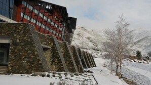A modern building with a stone facade and a red glass structure. - H2otel Congress & Medical Spa (Covilhã)