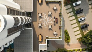 An aerial view of a modern building with a rooftop terrace featuring outdoor seating and a decorative geometric pattern. - Ekante Bliss IHCL SeleQtions  (Tirupati)