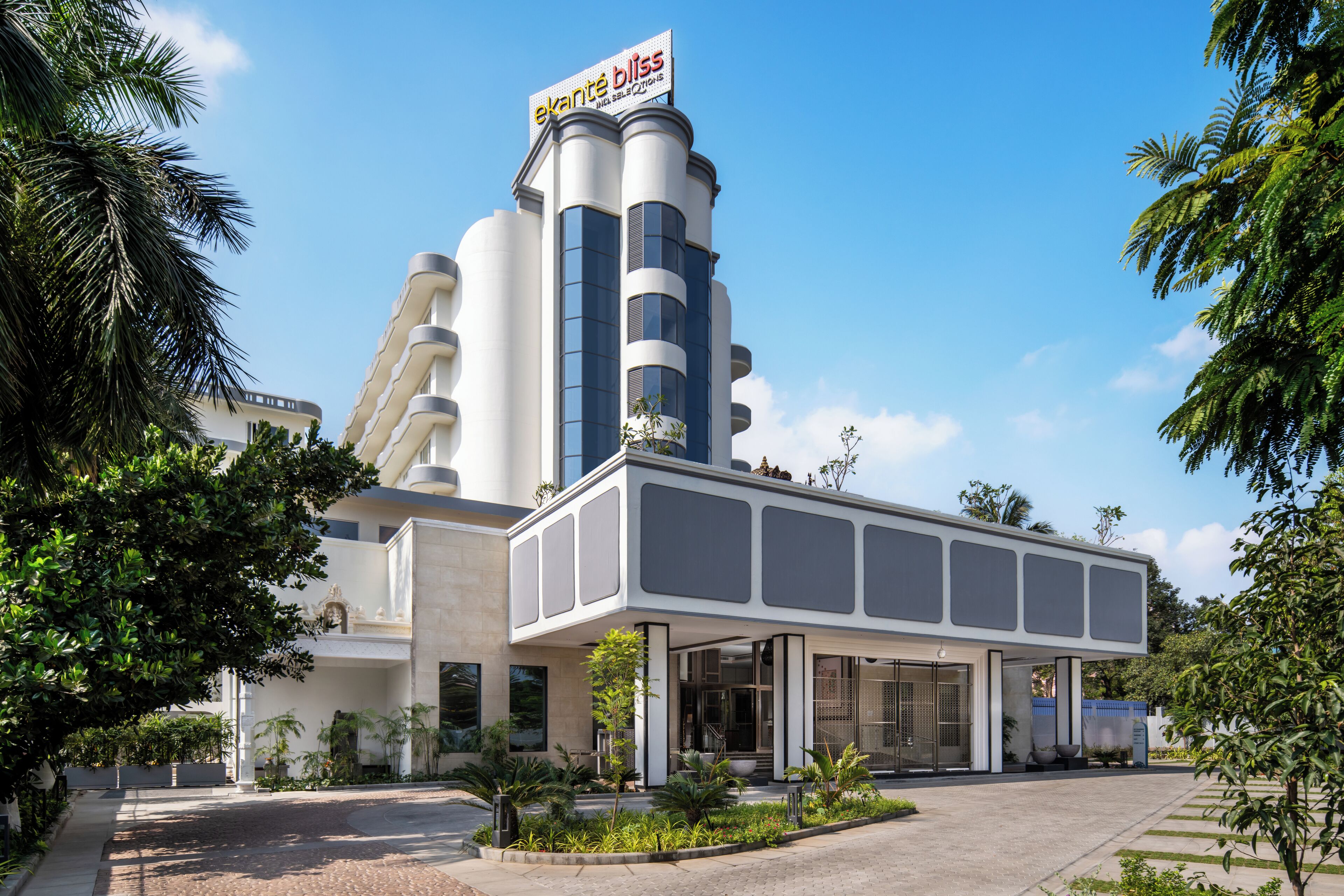 A modern hotel with a prominent tower and a covered entrance area.