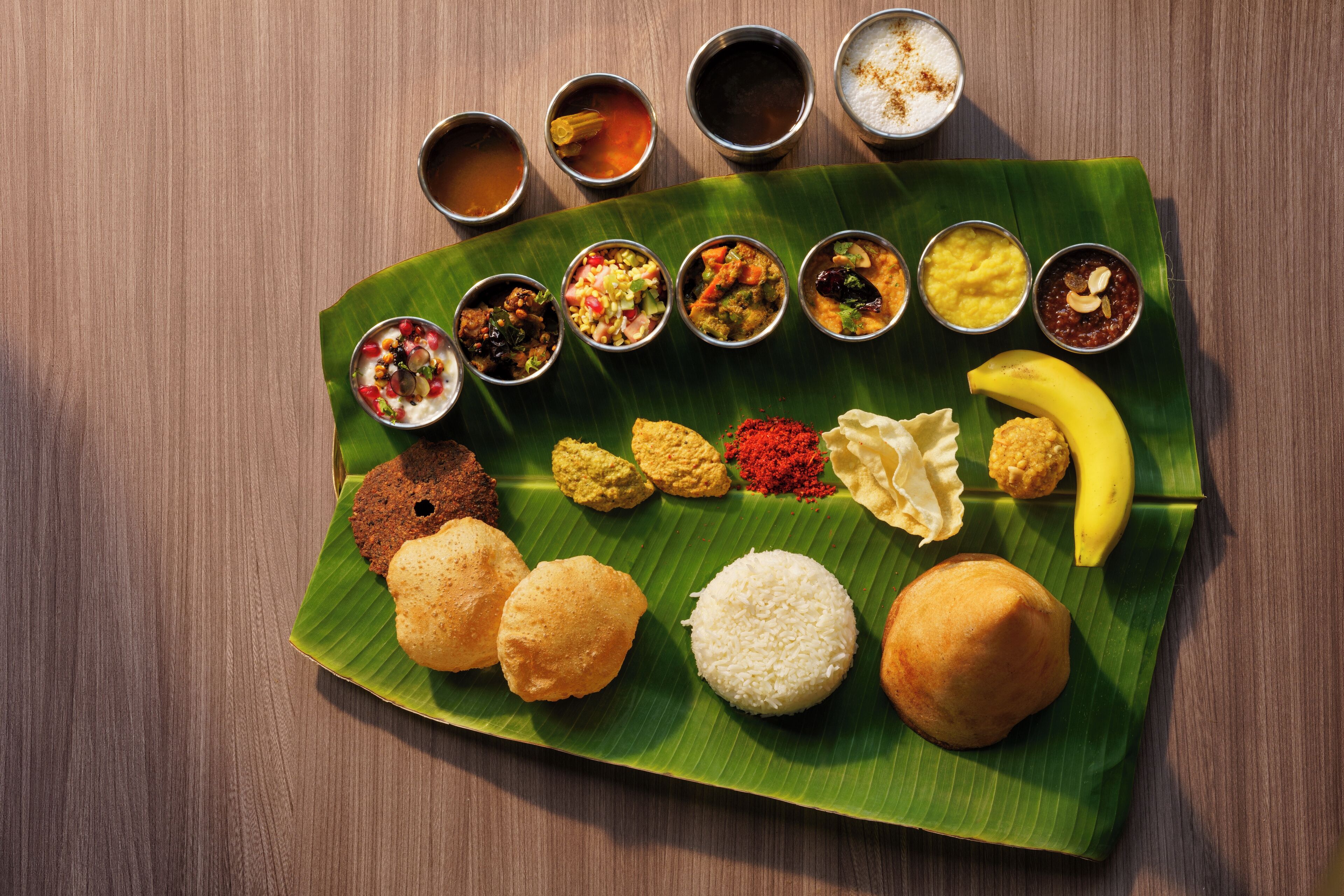 Erilaisia intialaisia ruokia on aseteltu banaaninlehdelle, ja niihin kuuluu riisiä, leipää sekä useita erilaisia chutney- ja currykastikkeita.
