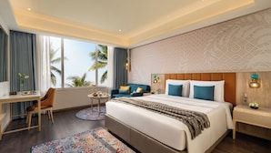 A modern hotel room with a large bed, a desk, and a view of palm trees. - Ekante Bliss IHCL SeleQtions  (Tirupati)