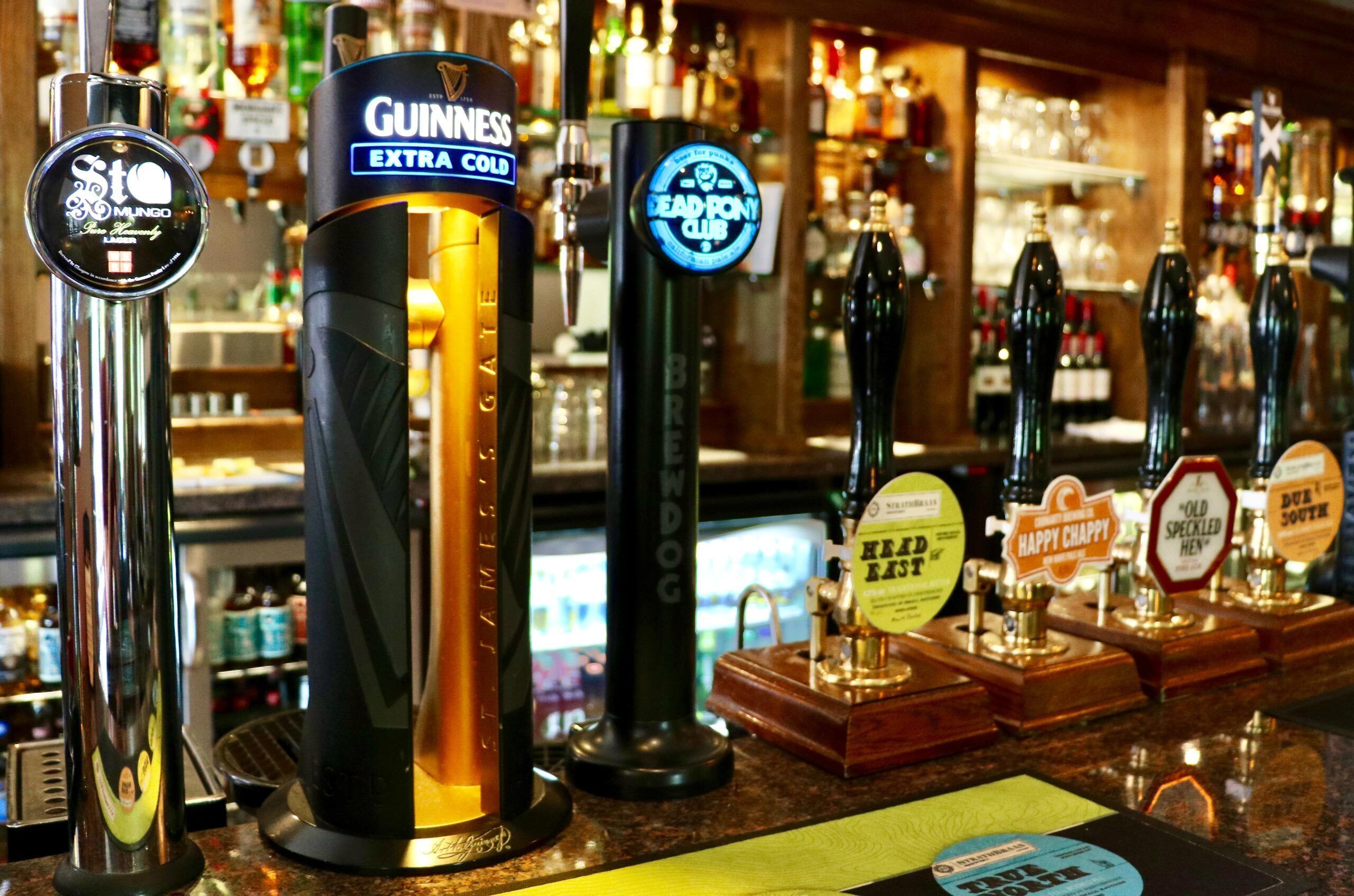 A bar with various beer taps including Guinness, St. Louis, and others.