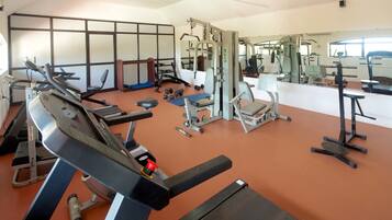 Una palestra con tapis roulant, macchinari per l'allenamento della forza e pesi liberi.