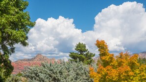 A landscape with trees, a clear sky, and mountains.