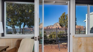 A room with a view of a canyon, a bench, and a door leading outside.