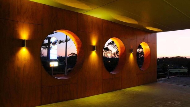 A modern building facade with circular windows and warm lighting. - Drouin Motel (Drouin)