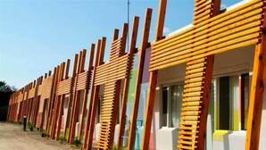 A row of wooden-framed rooms with large windows and a gravel driveway. - Drouin Motel (Drouin)