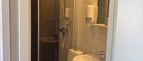 A bathroom with a toilet, sink, and shower.