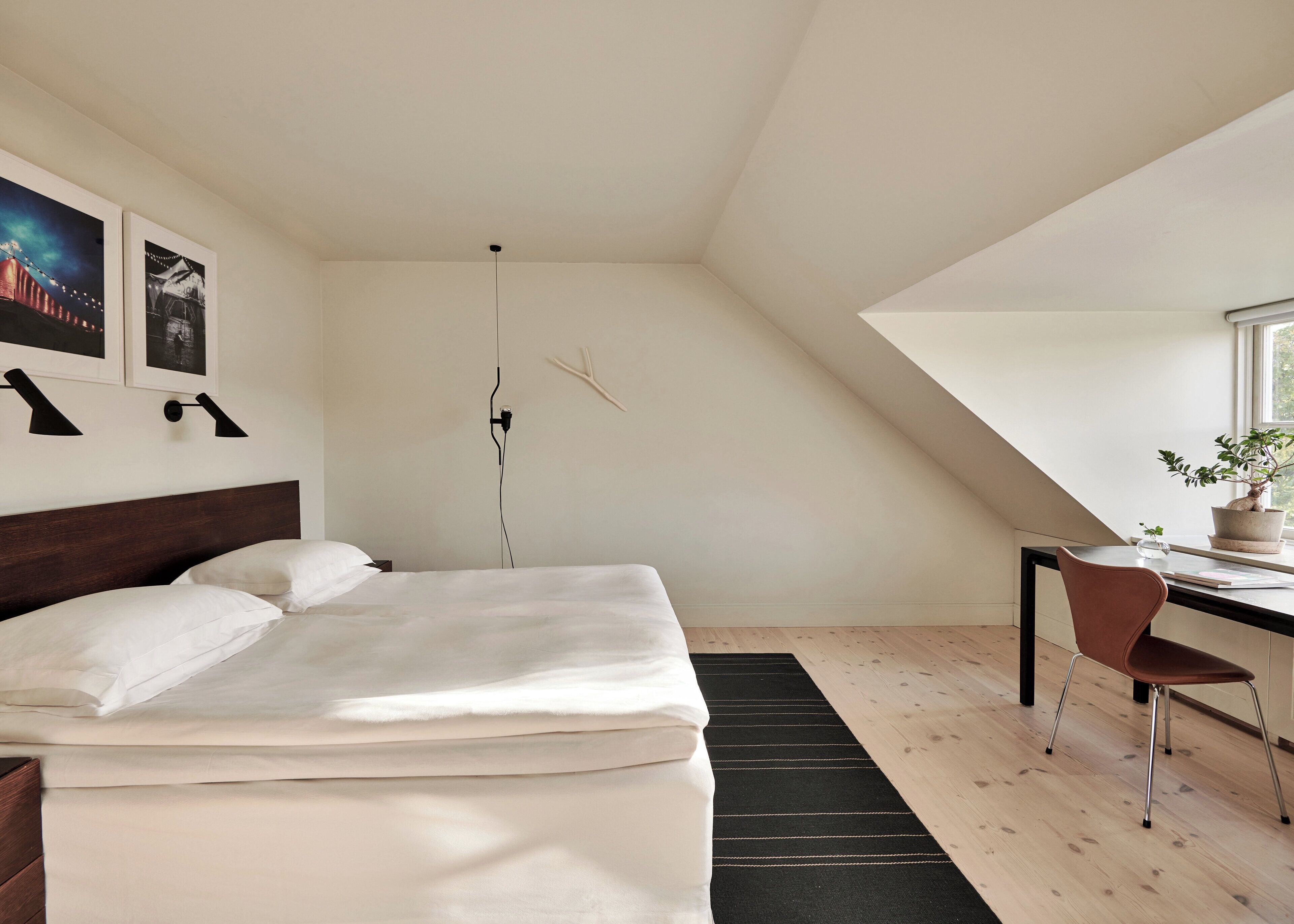 A bedroom with a bed, a desk, a chair, and a window.